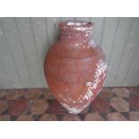 A terracotta tapered oviform jar with simple pinched ring bands and remains of later painted finish,