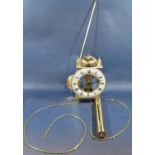A contemporary brass wall clock with skeleton frame, with pendulum and single weight by Hermle