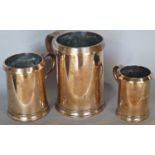 Three highly polished 19th century brass tankards in three measures, a quart, a pint and a half