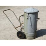 A vintage tubular steel framed two wheel trolley supporting an associated cylindrical galvanised