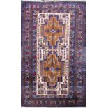 A Kazak style rug with an interlocking central lozenge shaped medallion. 145cm x 80cm