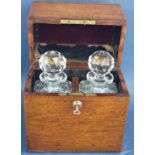 A Victorian oak travel drinking box containing a pair of cut glass square decanters, complete with