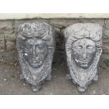 A pair of cast composition stone garden wall pockets, female face mask with long plaited hair, 28 cm