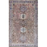 A Heriz rug with a pale brown field of geometric designs. 180cm x 105cm approx.