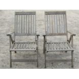 A pair of Winchester Collection weathered hardwood folding garden open armchairs with slatted