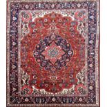 A fine Bokhara carpet with a central medallion and floral pattern on a red ground. 378cm x 285cm