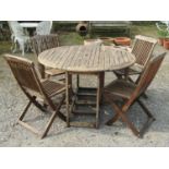 A weathered stained teak circular drop leaf gateleg garden table, 122 cm in diameter, together