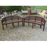 A pair of good quality contemporary stained teak banana shaped garden benches, 160 cm wide