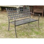 Weathered light steel two seat garden bench with lattice panelled seat and back, raised on swept and