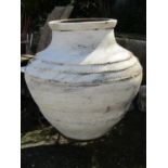 A substantial antique terracotta olive jar with glazed interior, thumb pressed ring and incised