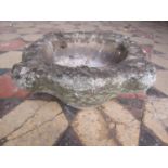 A small weathered carved stone mortar 30 cm diameter approx x 15 cm high (af)
