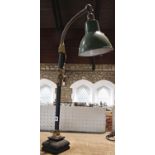 A mid 20th century metal desk lamp with brass adjustable hinges and a flexible pendant and a green