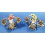 A pair of 19th century continental porcelain figures of parrots upon stumps within gilded brass