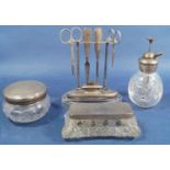 A Walker & Hall silver manicure stand, mounted on a glass stand, (missing glass pot) with later