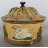 A 19th century painted oval lead tobacco jar with a domed cover and white swans to the side. (With