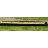 A vintage cast iron rectangular pig feeding trough with seven rung divisions 244 cm (8 ft) long x 31