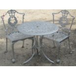 A cast aluminium garden terrace table of circular form with decorative scrolling foliate detail,