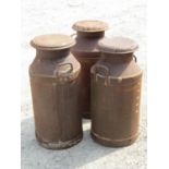 Three vintage heavy gauge but weathered galvanised steel two handled milk churns and caps, 72cm high