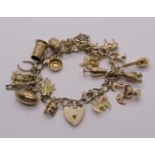 9ct charm bracelet hung with a collection of novelty charms to include a thistle, Tudor Rose, clover