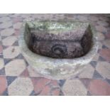 A weathered D shaped natural stone trough with circular drainage hole, 54cm wide x 41cm deep x