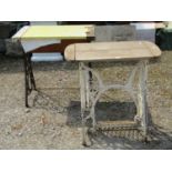 A Singer cast iron treadle sewing machine base with later painted finish beneath a timber top,