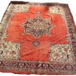A large country house Persian carpet with a central medallion on a predominantly salmon pink ground,