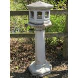 Three sectional bird table of octagonal form with simulated tiled roof and arched window