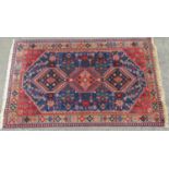 A Yellameh rug with three interlocking medallions and stylised floral motif on a blue ground,