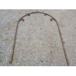 An old probably 19th century two sectional wrought iron arch of simple scroll work and partial