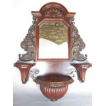 An Edwardian mahogany hall mirror with carved floral decoration and a central semi-circular ledge