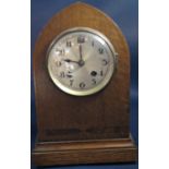 An Edwardian oak lancet shaped mantle clock with eight day striking movement