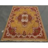 A large Persian style carpet with a central floral medallion on a predominantly yellow ground, 330cm