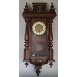 A late 19th century German wall clock with glazed front and split spindle mouldings, the dial with