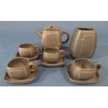 An oriental style tea set with symmetrical line pattern upon a dark brown ground comprising
