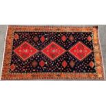 A Lori carpet with stepped diamond medallions on a dark blue ground interspersed with flower blooms,