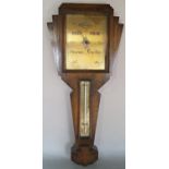 An Art Deco aneroid barometer in a shaped oak case, with gilded dials