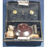 A tin containing a silver mounted bakelite pin dish, a vintage Medana wristwatch, silver tongs and