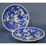 A pair of ceramic wall plates with all over blue and white prunus blossom decoration, 34cm