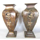 A pair of copper Art Nouveau square necked vases with embossed flowers and glass windows to