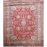 A large Persian style carpet with an overall floral pattern on a predominantly red ground, 366cm x