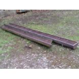 An unusual extremely long vintage cast iron pig feeding trough with simple open rung divisions,