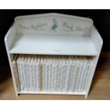 A miniature wooden bookcase containing a collection of Beatrix Potter books (1)
