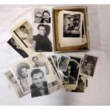 A box containing a collection of black and white studio type photographs and postcards of various