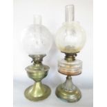 A Victorian brass oil lamp with a floral etched glass shade 48cm high, and another brass oil lamp
