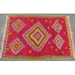 A Kilim with a central zig-zag edged central diamond medallion surrounded by similar medallions on a