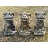 Three weathered cast composition stone garden ornaments in the form of dogs of fo, 50 cm high