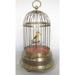 A 20th century automaton singing canary perched in a brass cage, in need of repair, 33cm high.