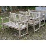 A weathered hardwood four piece garden suite comprising a pair of two seat benches with slatted