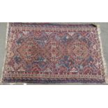 An old Persian rug with interlocking central diamond medallions, 150cm x 96cm approx