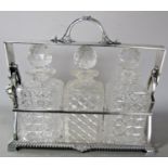 A good quality silver plated three bottle tantalus with cut glass decanters and stoppers, the